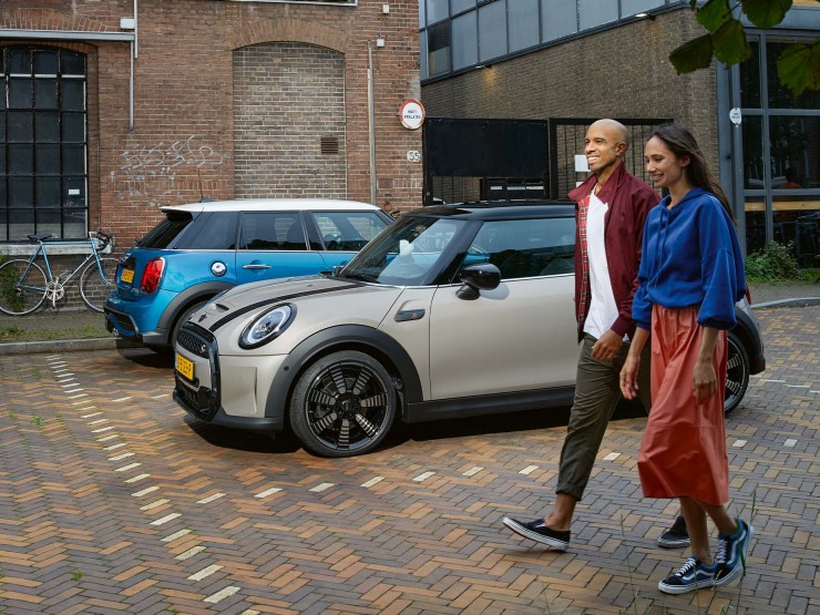 Man en vrouw lopen langs een grijze en blauwe MINI.