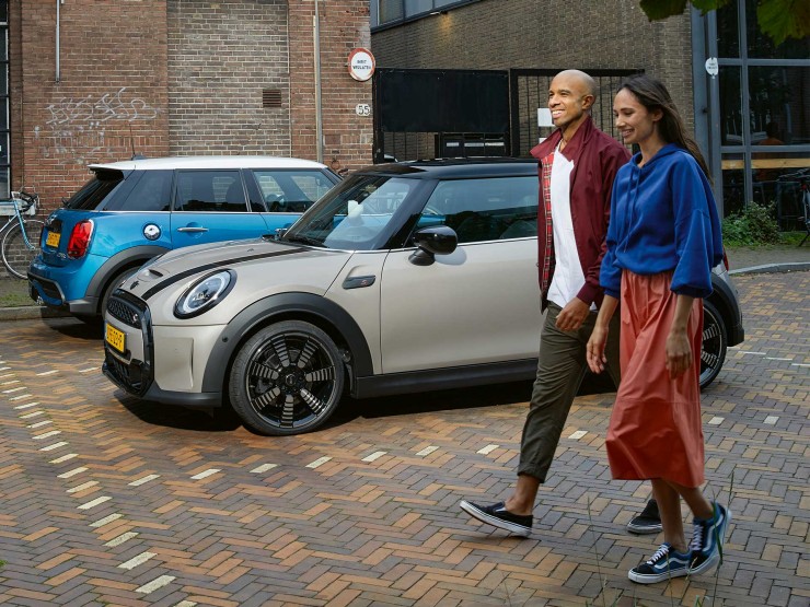 Man en vrouw lopen langs een grijze en blauwe MINI.