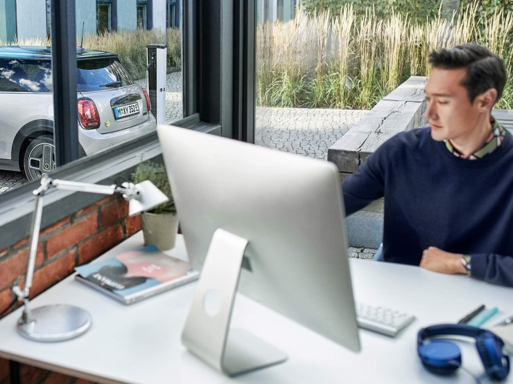 Man zit achter zijn computer met een MINI buiten.